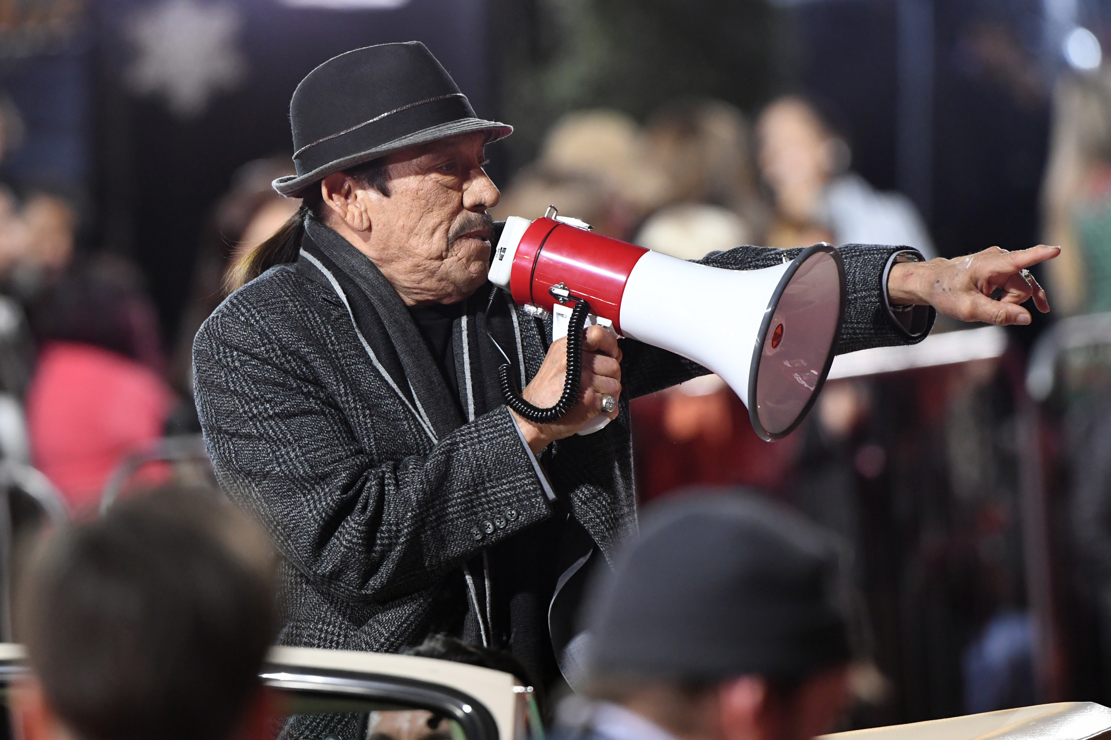 Danny Trejo speaks into a megaphone at an outdoor event