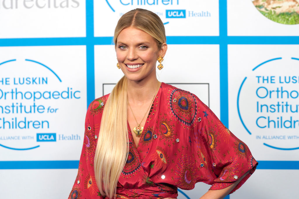 AnnaLynne McCord is in a patterned dress with long sleeves, posing at an event for the Orthopaedic Institute for Children, affiliated with UCLA Health