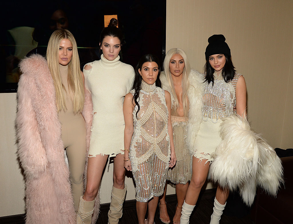Khloe Kardashian, Kendall Jenner, Kourtney Kardashian, Kim Kardashian, and Kylie Jenner posing together in stylish outfits, some featuring fur and intricate designs