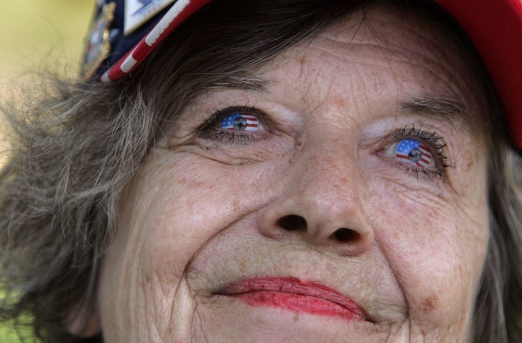Close-up of an elderly woman wearing a hat with American flag-themed contact lenses in her eyes