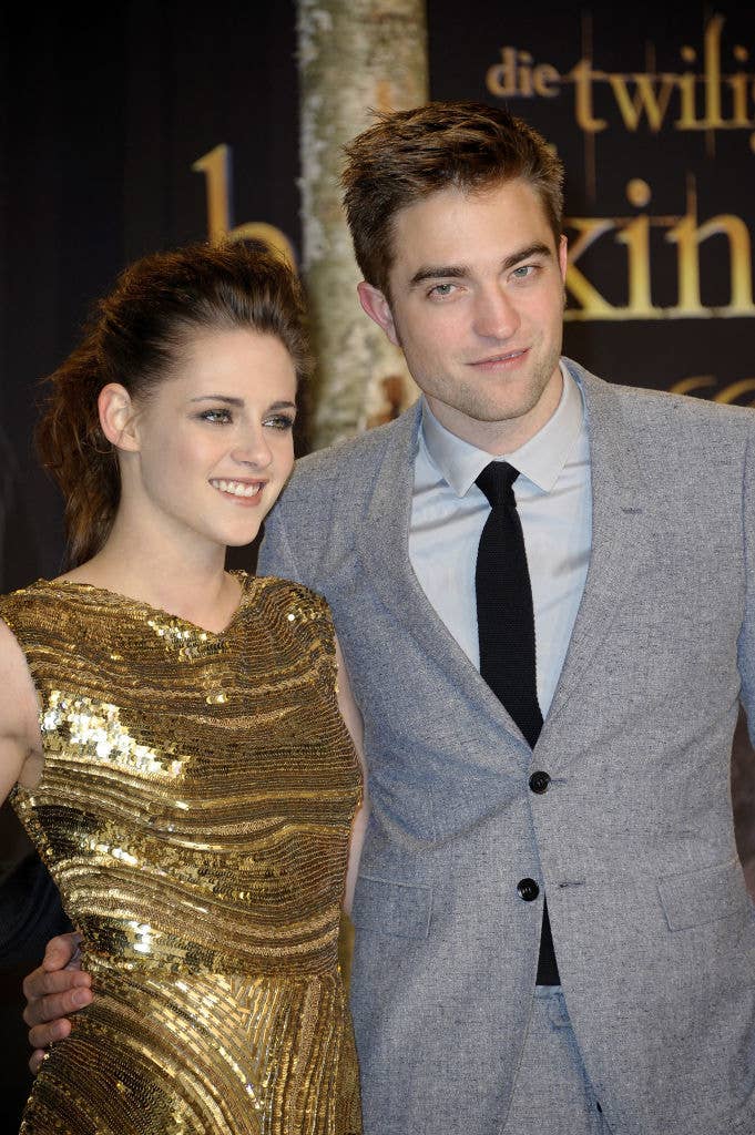 Kristen Stewart in a glittering dress and Robert Pattinson in a light suit with a black tie at a formal event
