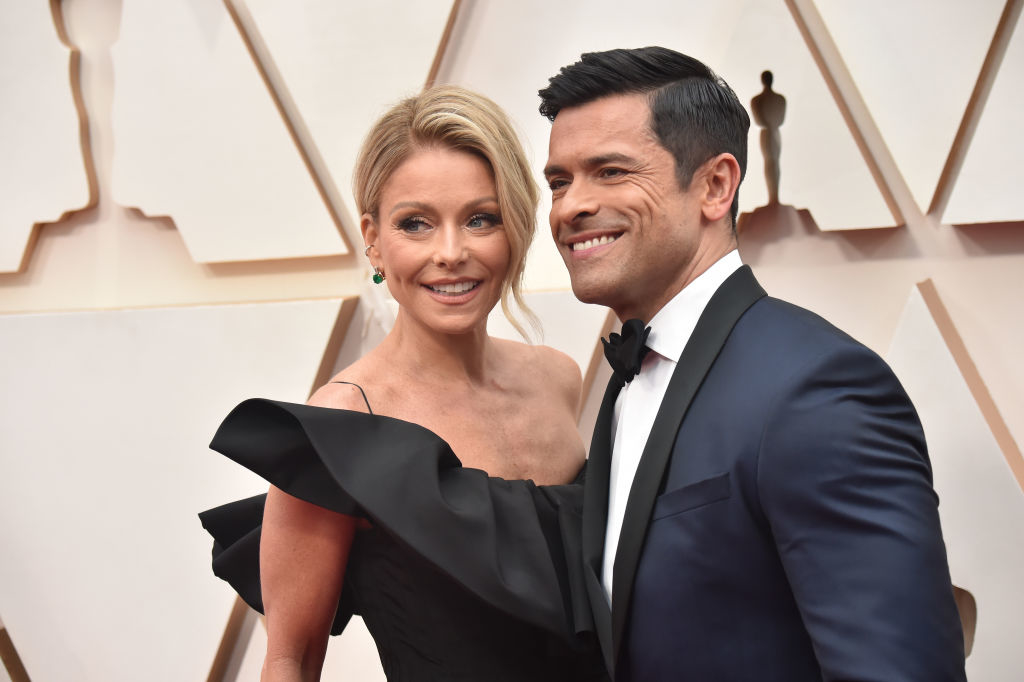 Kelly Ripa in a stylish, off-the-shoulder dress and Mark Consuelos in a tuxedo smile on the red carpet