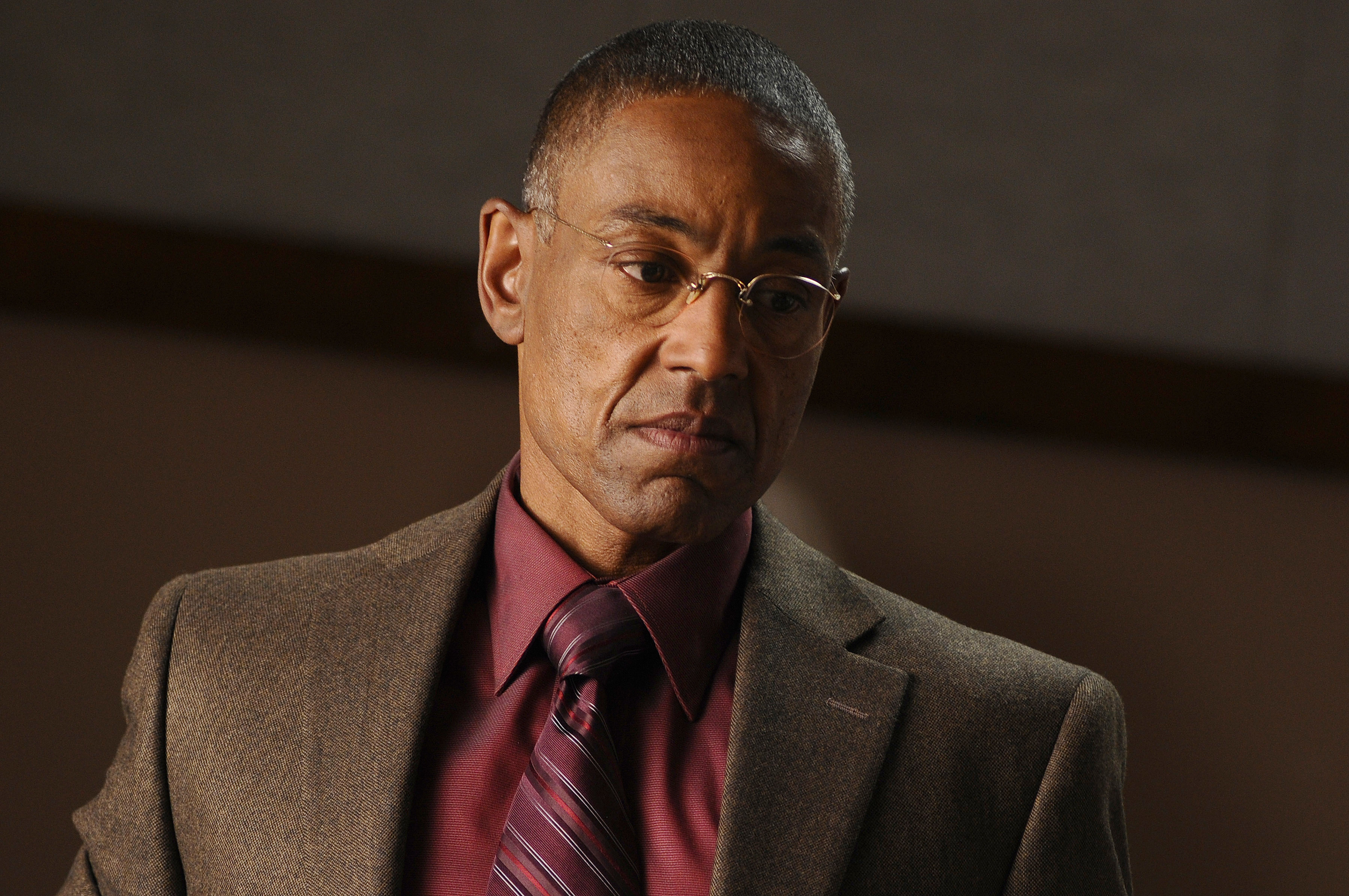 Giancarlo Esposito wearing a suit jacket with a dress shirt and tie, looking down pensively in a scene from &quot;Breaking Bad&quot;