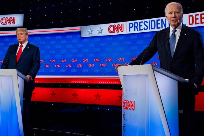 Donald Trump and Joe Biden stand at podiums during a CNN presidential debate. Both are dressed in suits. The CNN logo is visible in the background