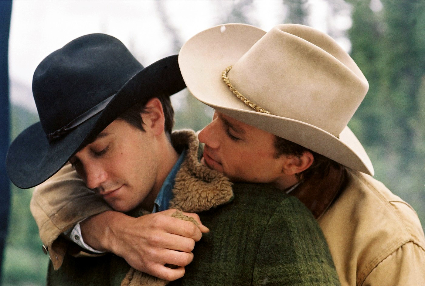 Jake Gyllenhaal and Heath Ledger in &quot;Brokeback Mountain&quot; embrace outdoors, wearing hats and winter clothing