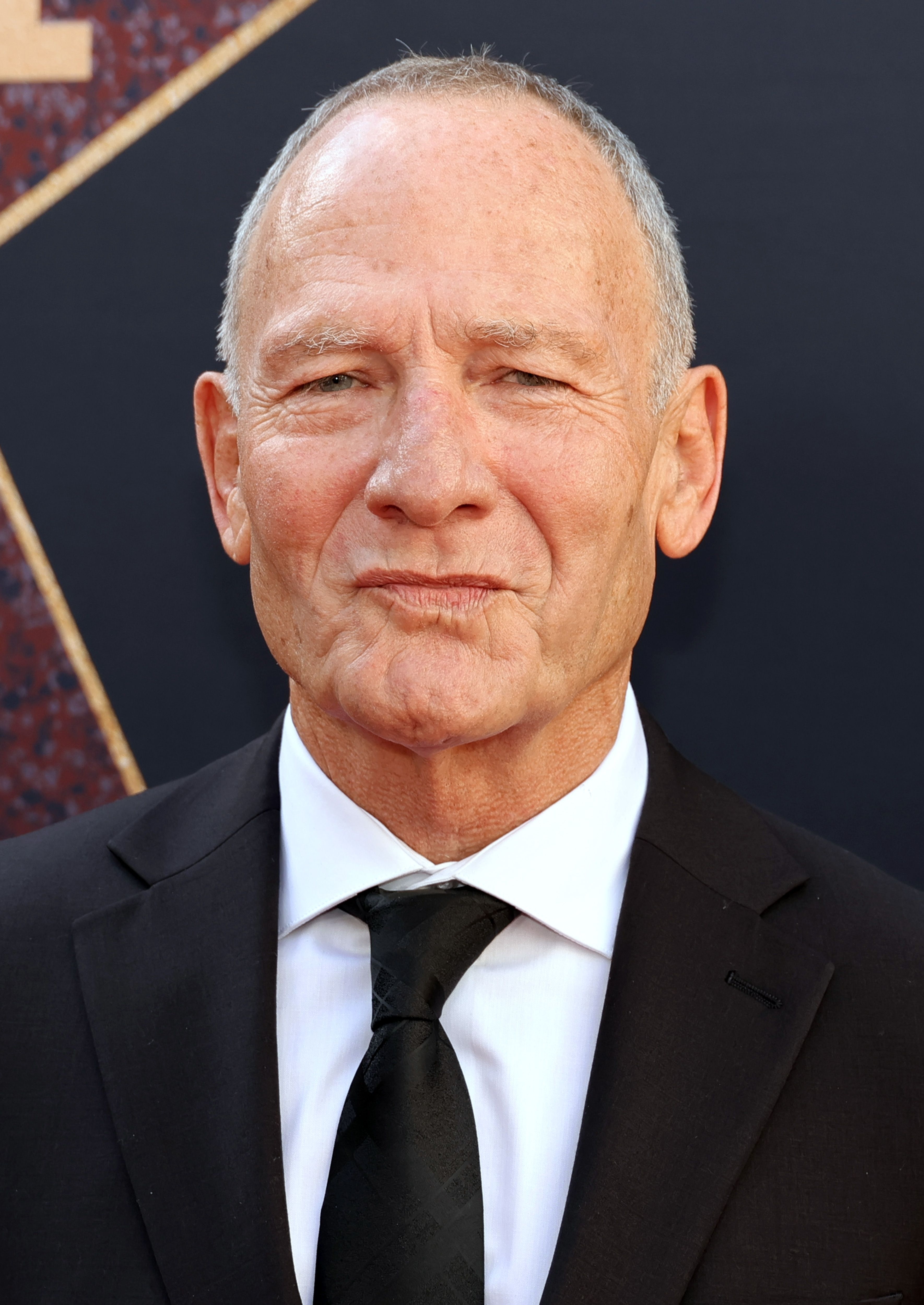 Simon Prast in a suit and tie at the premiere of &quot;MaXXXine&quot;