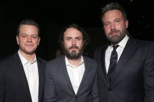 Matt Damon, Casey Affleck, and Ben Affleck in suits at a formal event