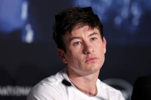 Barry Keoghan at a press event, wearing a casual white t-shirt, looking thoughtfully into the distance