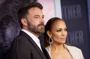 Ben Affleck and Jennifer Lopez pose at a formal event. Ben wears a suit, and Jennifer wears a stylish beige outfit with a bralette and blazer