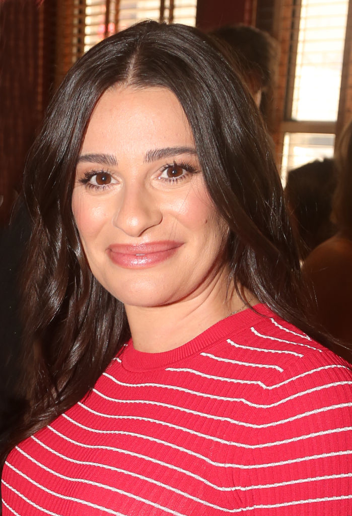 Lea Michele smiling at the camera, wearing a striped top