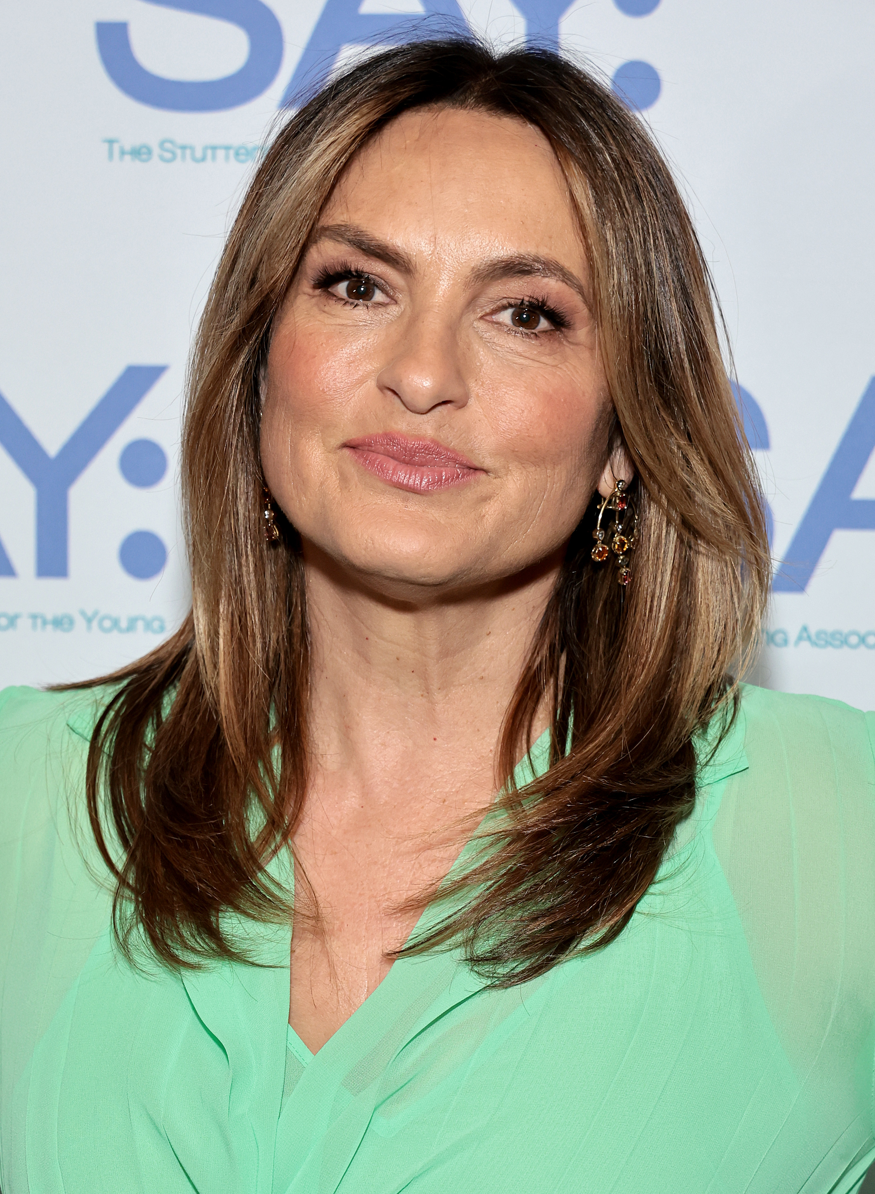 Mariska Hargitay at an event, wearing a stylish, elegant outfit with subtle earrings, smiling for the camera