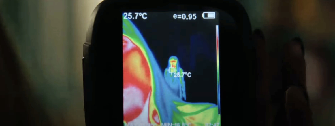 Thermal camera display showing a person emitting heat, indicated by different thermal colors, with a temperature reading of 25.7°C. No recognizable individuals