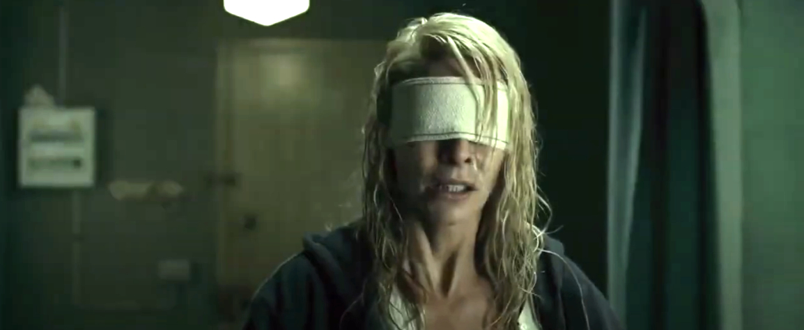 A woman, with wet hair and a blindfold, appears distressed in a dimly lit room