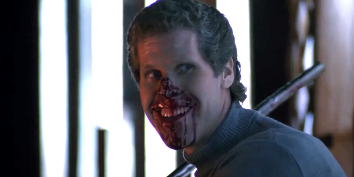 A man from a TV or movie scene sports a chilling smile as his face is bloodied, implying a dramatic or intense moment in the storyline