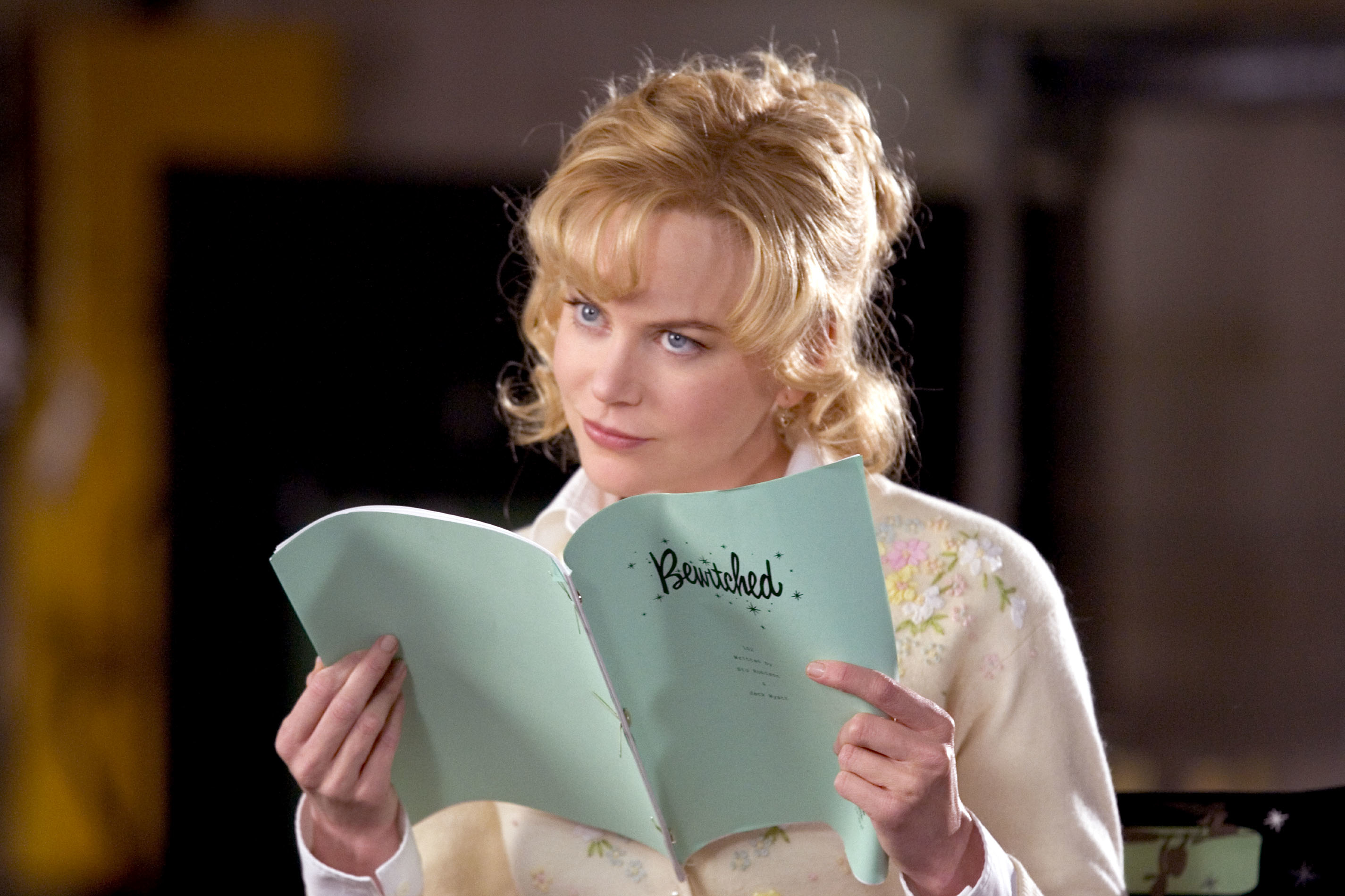 Nicole Kidman is reading a &quot;Bewitched&quot; script while dressed in a vintage-style outfit with a floral print sweater