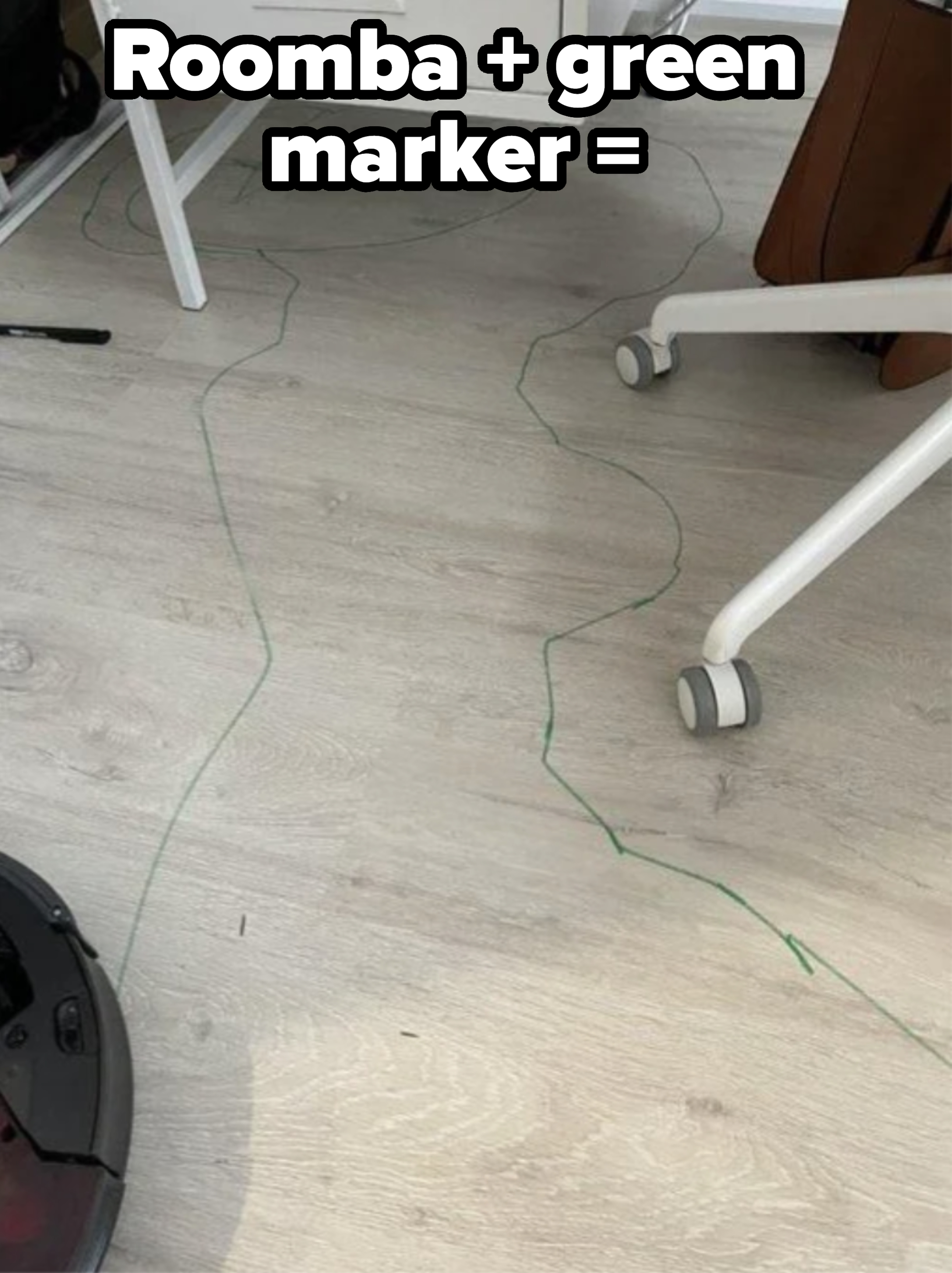 Robot vacuum has drawn a green outline on the floor around a desk, chair, and other furniture legs, likely tracing its path