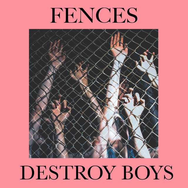 Hands of several individuals reaching through a chain-link fence. Text reads: &quot;Fences Destroy Boys.&quot;