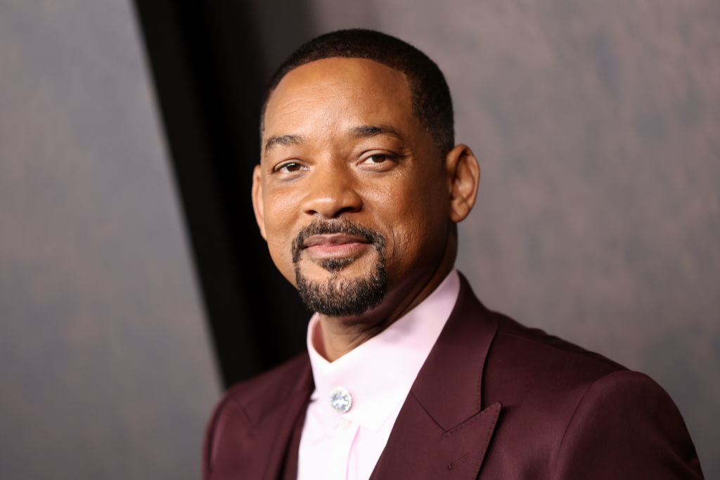 Will Smith smiles, wearing a tailored suit with a light-colored shirt