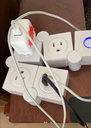 Overloaded power strip with multiple plugs and cords connected, posing a safety hazard