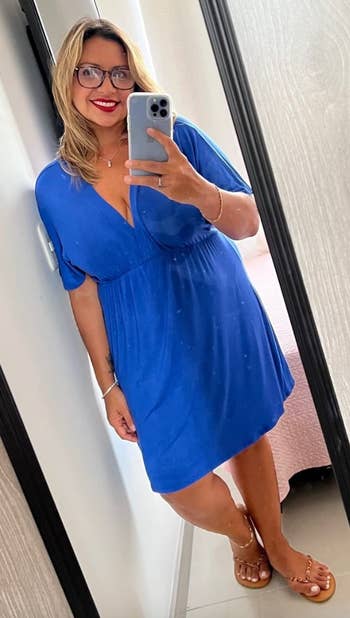 reviewer in blue knee-length V-neck dress