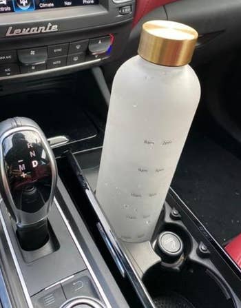 water bottle in a car cup holder twisted to show time markings on it 