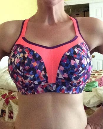 reviewer wears underwire sports bra with cool pink and purple pattern on the front