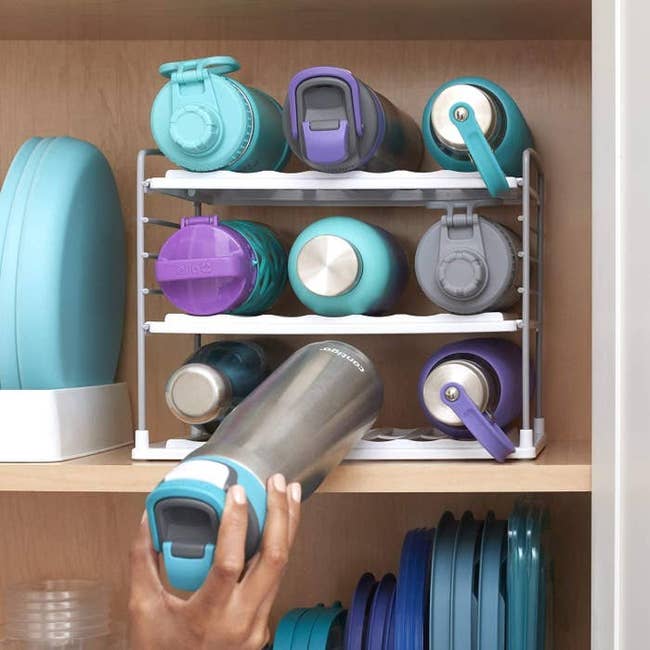 model placing bottle on the rack inside cabinet