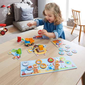 Young child playing with educational toys on a table in a brightly lit room