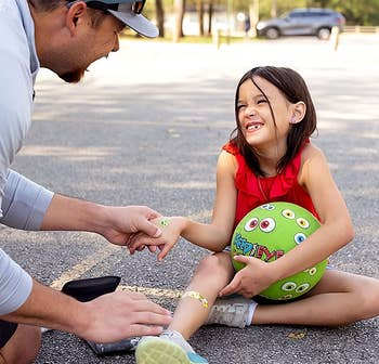 parent putting bandage on child's leg