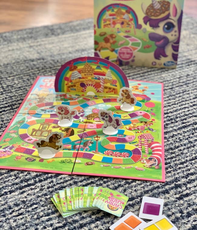 Candy Land Unicorn Edition game setup with board, character pieces, cards, and box shown