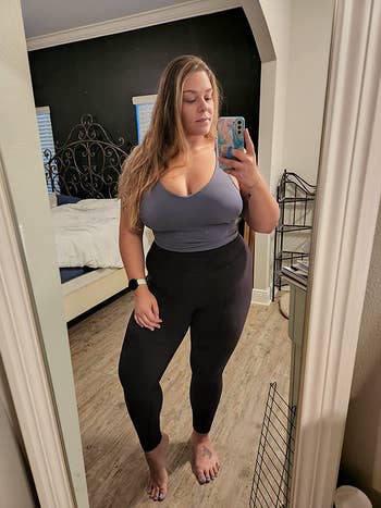 reviewer wearing dark purple long line sports bra with high-rise black leggings