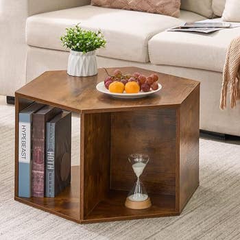 hexagon coffee table with a plant and plate of fruit on top