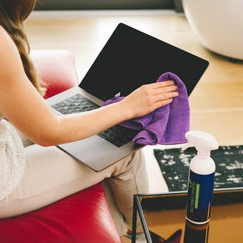 model using spray and cloth to clean laptop screen