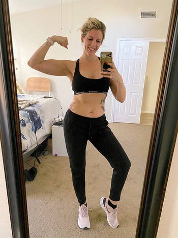 reviewer in same sports bra in a black shade and black leggings