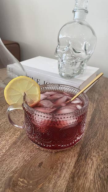 A glass mug with subtle dot sunflower print holding iced tea  