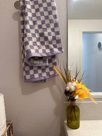 a purple checkered towel hanging in a bathroom