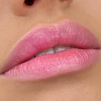 Close-up of a person's lips wearing pink lipstick