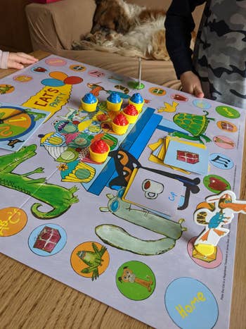 review image of children playing a colorful children's board game involving cupcakes on a table
