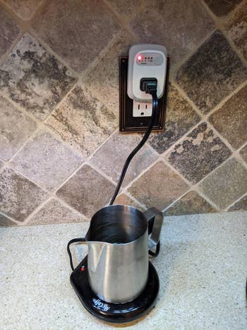 reviewer's mug warmer plugged into the auto shutoff outlet