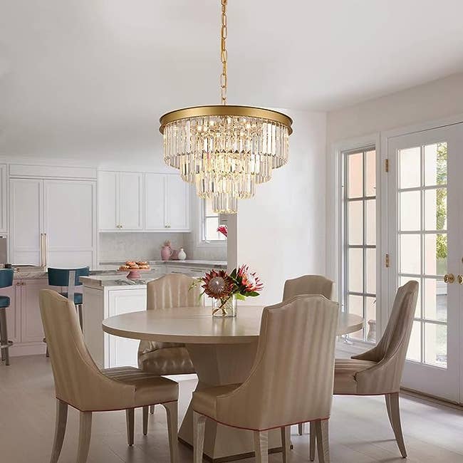 three-tiered crystal chandelier hanging over a dining room table