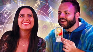 Woman smiling, Tarot reader smiling showing The Sun Tarot card, zodiac chart and Tarot cards In background