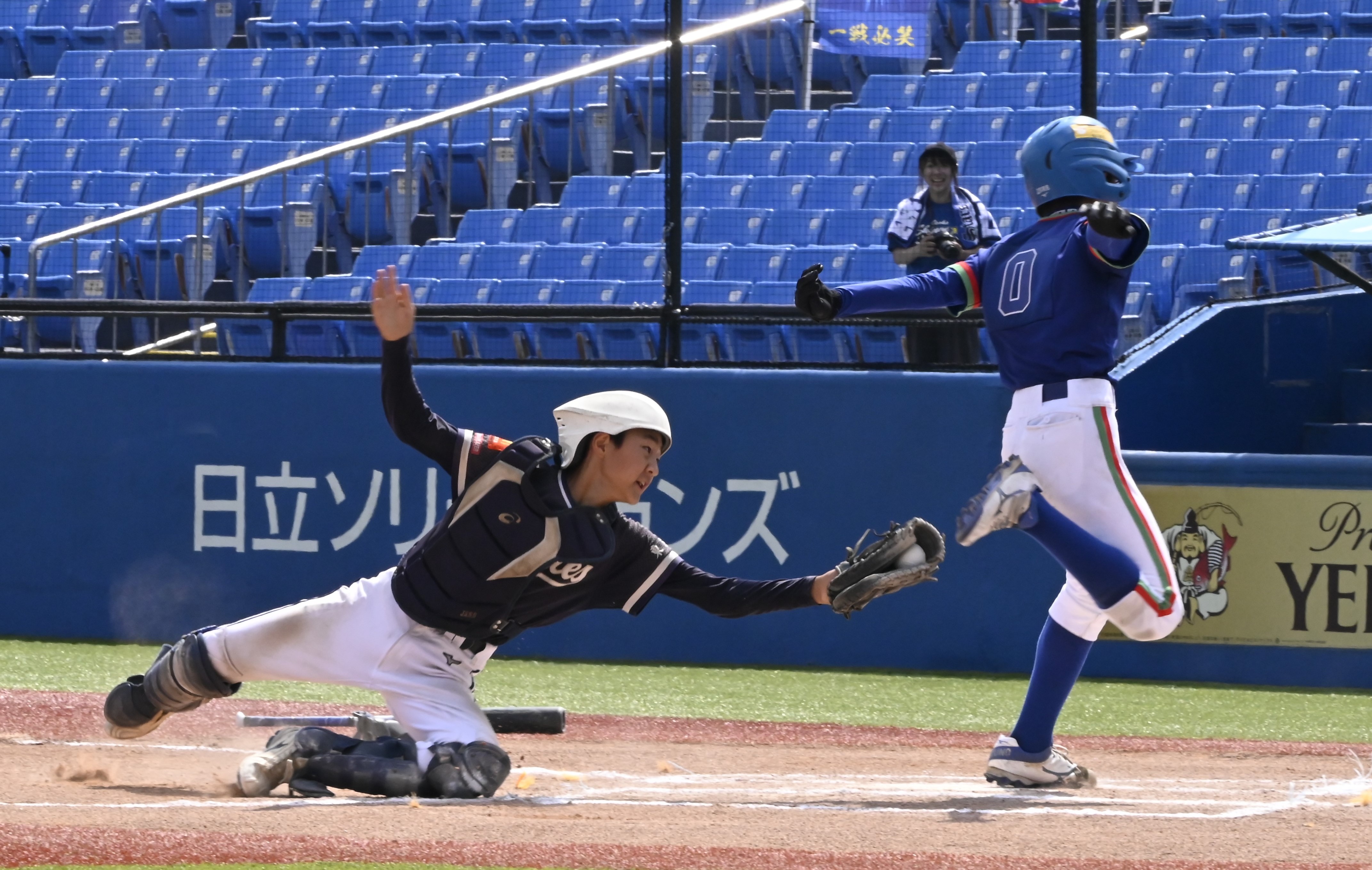 四回、内野安打で二塁から一気に生還した新家スターズの山田と不動パイレーツの捕手鎌瀬（21日、神宮球場＝浅水優佳撮影）