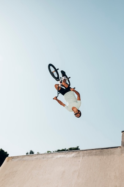 Bezpłatne zdjęcie człowiek na rowerze bmx wykonywania skoku w skateparku