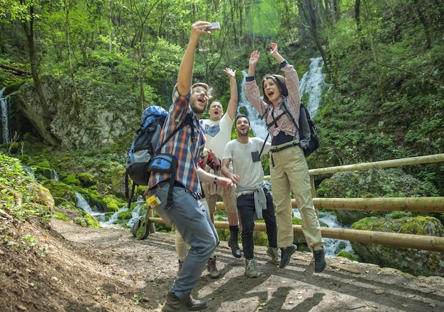 Bezpłatne zdjęcie grupa przyjaciół, którzy bawią się i robią selfie na łonie natury