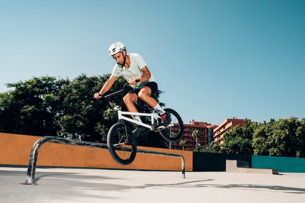 Bezpłatne zdjęcie jeździec bmx wykonujący sztuczki w skateparku