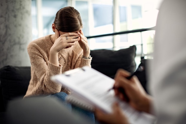 Bezpłatne zdjęcie kobieta z depresją podczas sesji psychoterapii w gabinecie lekarskim