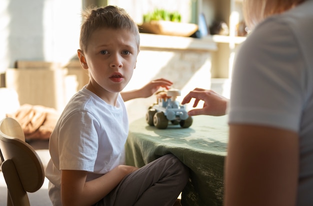 Matka bawi się z autystycznym synem za pomocą zabawek