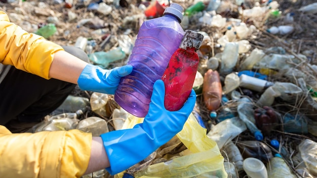 Bezpłatne zdjęcie mężczyzna zbiera z ziemi porozrzucane plastikowe butelki