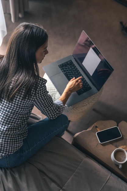 Młoda kobieta pracująca na laptopie w domu