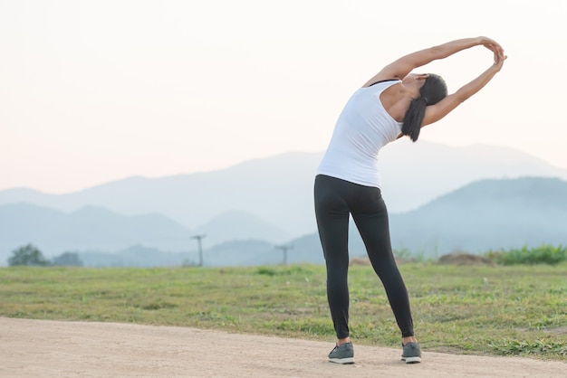 Bezpłatne zdjęcie młoda kobieta treningu przed treningiem fitness w parku.